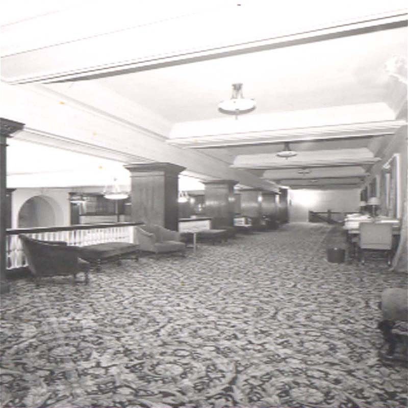 Hotel corridor with patterned carpet and seating areas